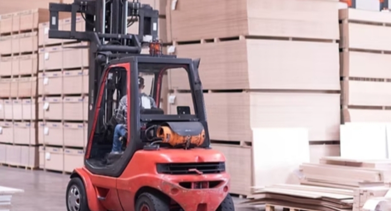 Workers in safety gear operating fire fighting equipment in an industrial setting, surrounded by machinery and safety signs, focused and alert